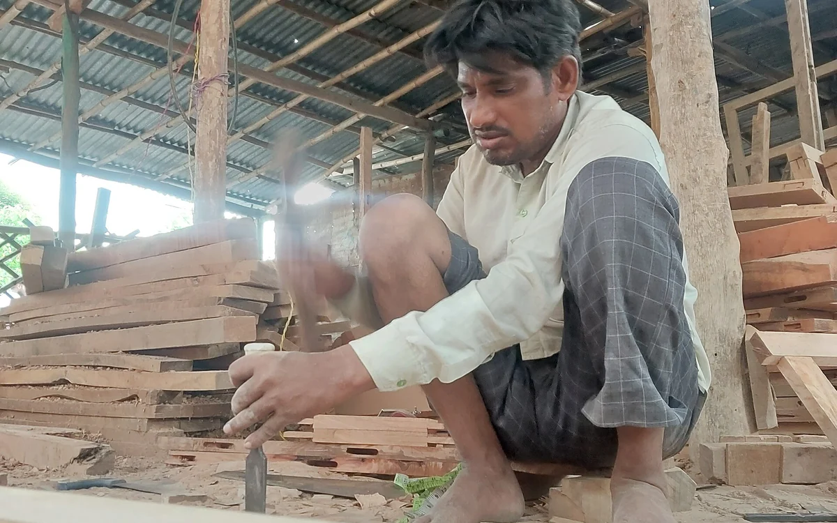 Menuisier travaillant une pièce de bois dans un atelier